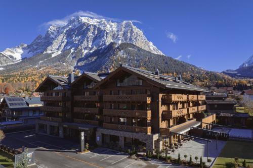 a large building with a mountain in the background at Bergresort Zugspitze Ehrwald by ALPS RESORTS in Ehrwald