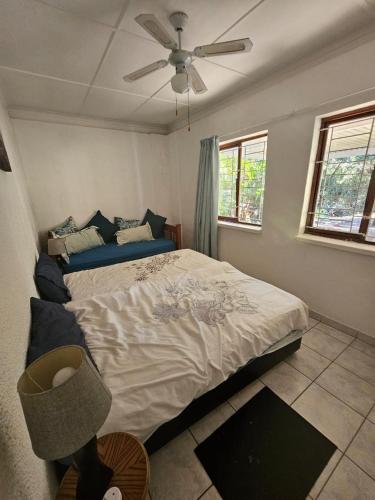 a bedroom with a bed and a ceiling fan at Villa Rosseau in Freeland Park
