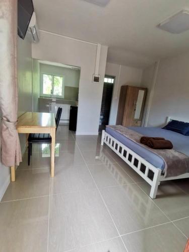 a bedroom with a bed and a desk and a table at Rainbow Bungalow Haadrin Koh Phangan in Haad Rin