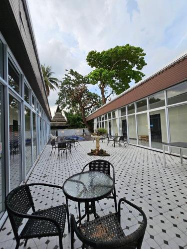 a patio with a table and chairs and a building at Mercy Hostel in Chiang Rai