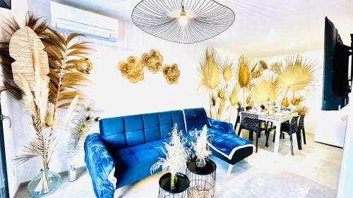 a living room with a blue couch and a table at Les Gîtes de la Chapelle 3 in Vauvert