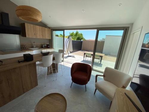 une cuisine et un salon avec une table et des chaises dans l'établissement maison centre ville, à Lagord