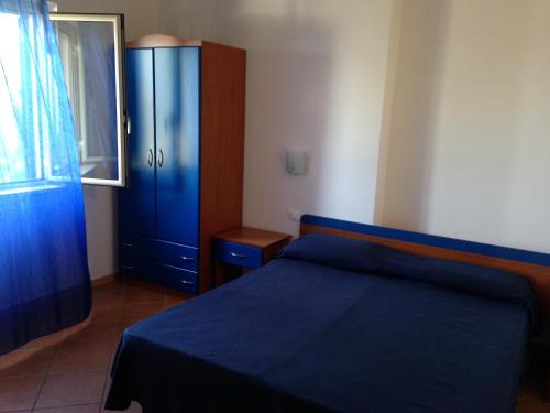 サンタ・ドメーニカにあるResidence Floritalia - Ricarica auto elettricheのベッドルーム1室(青いベッド1台、青いキャビネット付)