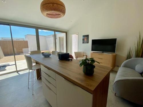 Cette chambre dispose d'un bureau, d'une télévision et d'un canapé. dans l'établissement maison centre ville, à Lagord