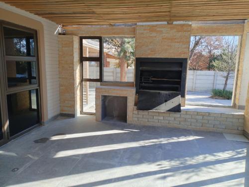 a patio with a brick fireplace in a house at Luyana guesthouse in Kroonstad