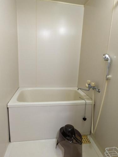 a white bath tub in a bathroom with a trash can at Space Noa201 in Tokyo