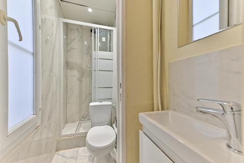 une salle de bain blanche avec des toilettes et un lavabo dans l'établissement Agréable Studio #Montmartre #SacréCœur, à Paris
