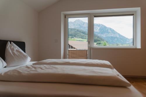 a bedroom with a bed and a large window at Kalkalpen Apartments in Spital am Pyhrn