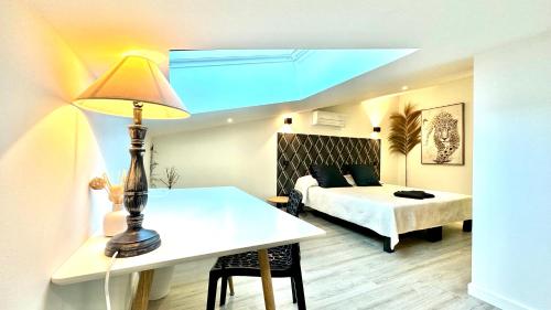 une chambre avec un lit et une table avec une lampe dans l'établissement Les Gîtes de la Chapelle 3, à Vauvert