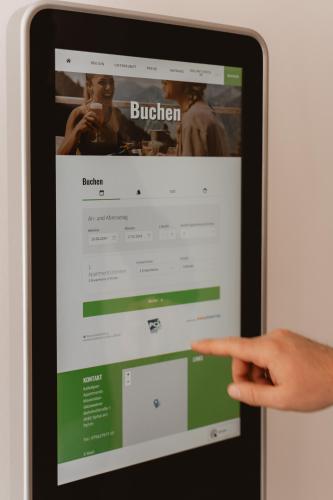 a person pointing at the browser on an ipad at Kalkalpen Apartments in Spital am Pyhrn