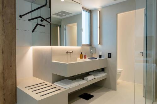 a bathroom with a sink and a mirror at Domes White Coast Milos, Adults Only - Small Luxury Hotels of the World in Mytakas