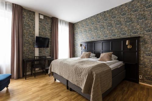 a bedroom with a large bed and a tv at Mössebergs Kurort in Falköping