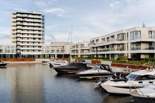 a group of boats docked in a marina with buildings at Sol Marina Resort Wyspa Sobieszewska II - LoftAffair Collection in Wiślinka