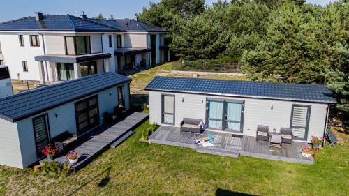 an aerial view of a tiny house with a deck at "AGUŚ" Komfortowe i nowczesne domki w cichej okolicy niedaleko plaży in Ostrowo