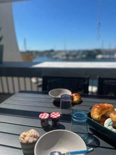 - une table avec un plateau de pain et des viennoiseries dans l'établissement Le Plaisancier - Appartement Terrasse Vue sur le Port de Plaisance parking, au Grau-du-Roi