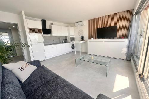 un salon avec un canapé et une table en verre dans l'établissement Le Plaisancier - Appartement Terrasse Vue sur le Port de Plaisance parking, au Grau-du-Roi