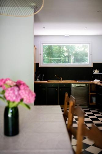 une cuisine avec une table et un vase de fleurs dans l'établissement Gîte du vieux chêne - 6pers. - Jardin arboré, à Ault