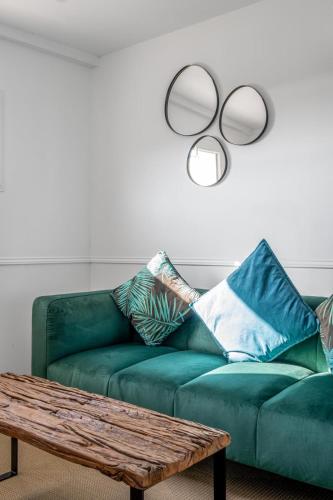 a living room with a green couch and a coffee table at Bella Vista Hôtel, Suites & Maisons in Porticcio