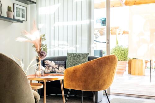 a living room with a couch and a table at Bella Vista Hôtel, Suites & Maisons in Porticcio