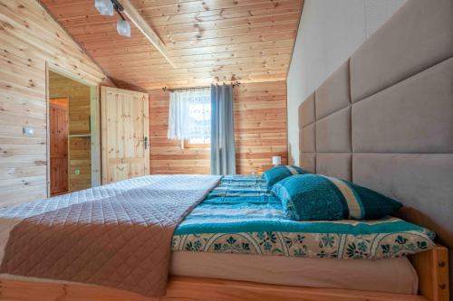 Un dormitorio con una cama en una cabaña de madera. en Domki letniskowe Ranczo, en Darłowo