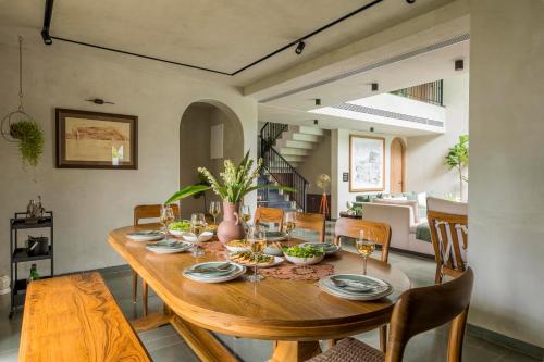 een eetkamer met een houten tafel en stoelen bij VaNa - A Lindsay Manor in Vagator