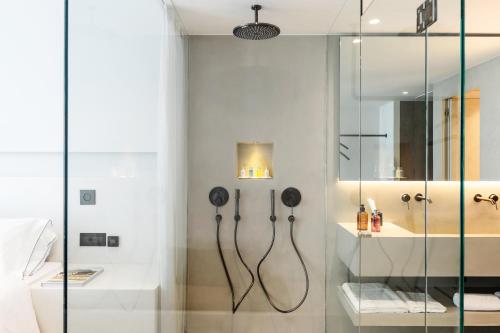 a bathroom with a shower with a glass wall at Domes White Coast Milos, Adults Only - Small Luxury Hotels of the World in Mytakas
