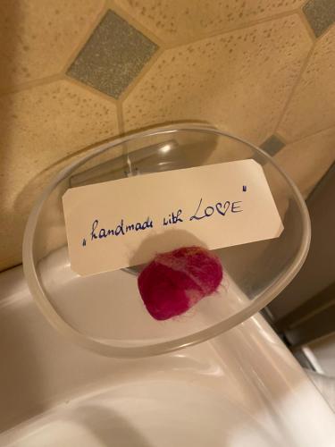 a piece of food on a glass plate with a note at Älpler Stuba Appartements am Lärchenhof in Warth am Arlberg