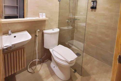 a bathroom with a toilet and a shower and a sink at Cebu Uncle Toms Cabin Hotel powered by Cocotel in Cebu City