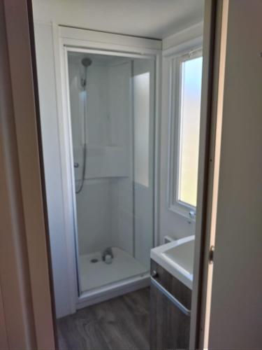 une salle de bain blanche avec une douche et un lavabo dans l'établissement Domaine du phare, à Le Portel