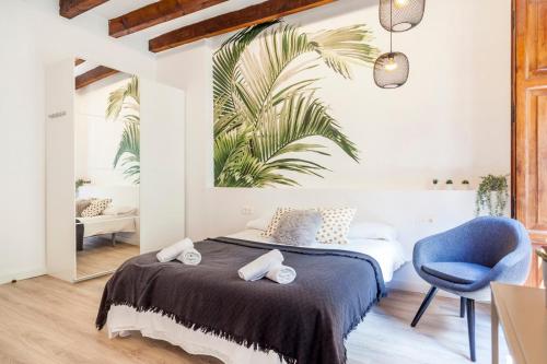 a bedroom with a bed and a blue chair at Modern Flat by Mercado Central in Ciutat Vella in Valencia