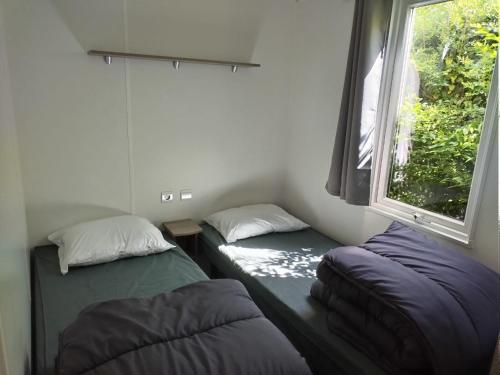 deux lits assis dans une pièce avec une fenêtre dans l'établissement Domaine du phare, à Le Portel