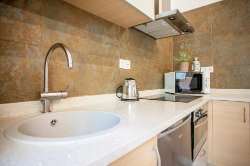a kitchen with a sink and a microwave at Modern Flat by Mercado Central in Ciutat Vella in Valencia