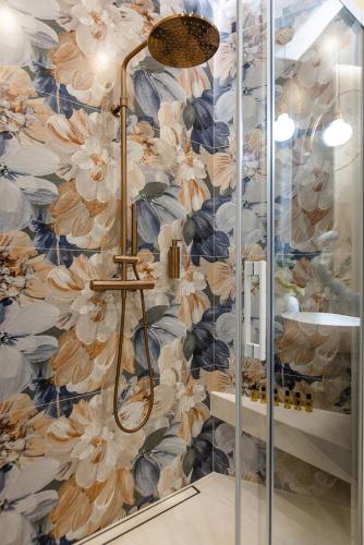 a bathroom with a shower with a floral wallpaper at Apartament LUNA z jacuzzi Premium na Mazurach in Ełk