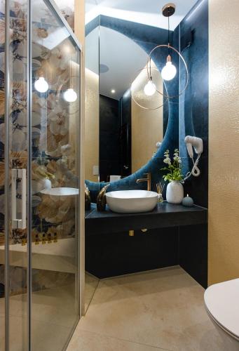 a bathroom with a sink and a mirror at Apartament LUNA z jacuzzi Premium na Mazurach in Ełk
