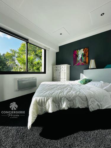 une chambre avec un grand lit et une grande fenêtre dans l'établissement Appartement lumineux et moderne - Le Tropical, à Royan