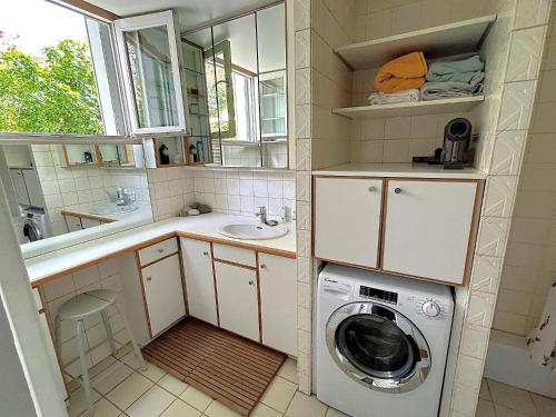 une petite salle de bains avec un lave-linge. dans l'établissement Loft Orfila, à Paris