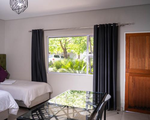 a room with a bed and a glass table and a window at Patterson B&B in Newcastle
