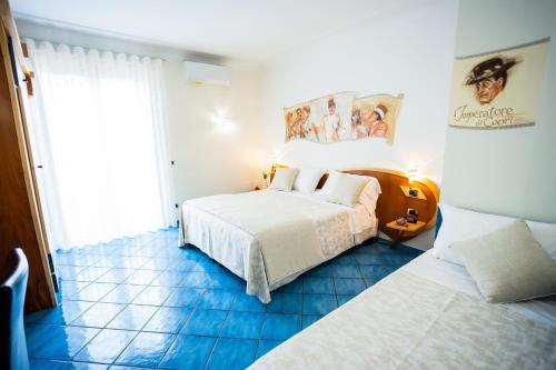 a bedroom with two beds and a blue tiled floor at Il Principe Resort in Agerola