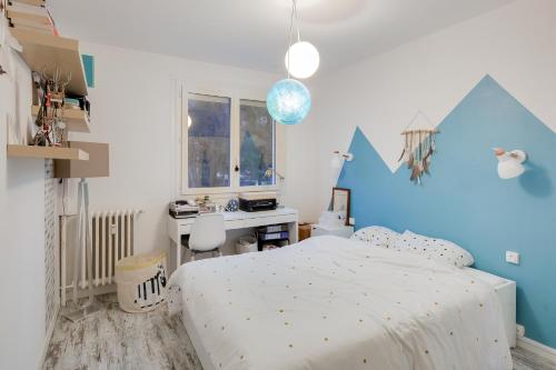 a bedroom with a bed and a desk in it at Comme chez vous - 3 chambres et un canapé-lit in Saint-Sébastien-sur-Loire