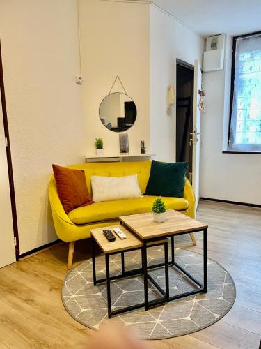 un salon avec un canapé jaune et une table dans l'établissement Cocon de Zoé, à Nancy