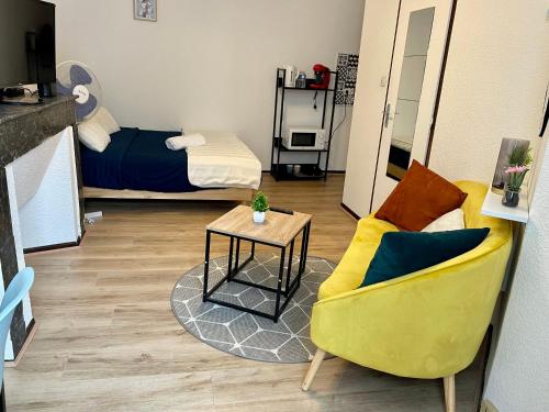 un salon avec un canapé jaune et une table dans l'établissement Cocon de Zoé, à Nancy