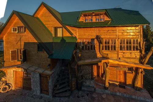 a large wooden house with a green roof at Guesthouse Planinarski dom Neviđen'o in Žabljak
