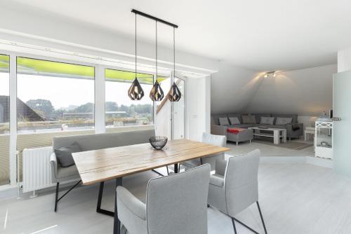a dining room with a wooden table and chairs at Golfresidenz Wohnung 211 in Grömitz
