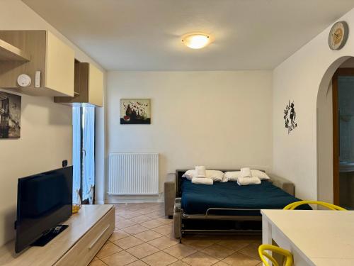 a bedroom with a bed and a flat screen tv at 1Dest - La Corte in Riva del Garda