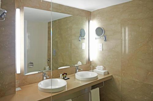 a bathroom with two sinks and a large mirror at Sunrise Beach Hotel in Protaras