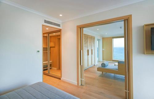 a bedroom with a view of a room with a window at Sunrise Beach Hotel in Protaras