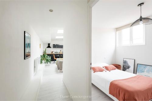 - une chambre avec des murs blancs et un lit avec des draps orange dans l'établissement Coeur des Chartrons, à Bordeaux