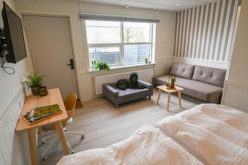 a bedroom with a bed and a couch and a table at Rold Gl Kro in Arden