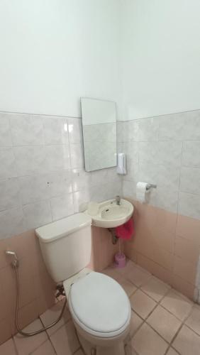 a bathroom with a toilet and a sink at Villa Dalia Puncak H1-26 in Cikundul