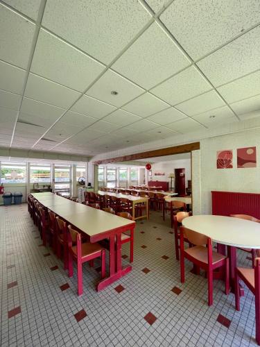 une salle à manger avec tables, chaises et fenêtres dans l'établissement La Baleine Blanche - Chambres, à Campan